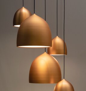 Copper-tone dome pendant shades hung at different heights