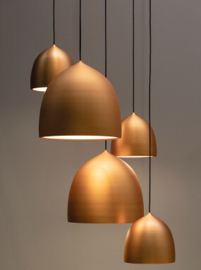 Copper-tone dome pendant shades hung at different heights