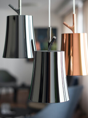 Flared pendant lights with a mirror-like silver finish and one copper-tone shade