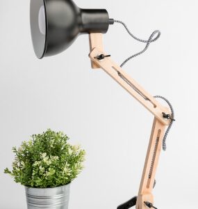 Adjustable desk lamp with a jointed light wood arm, black dome shade and grey braided cord
